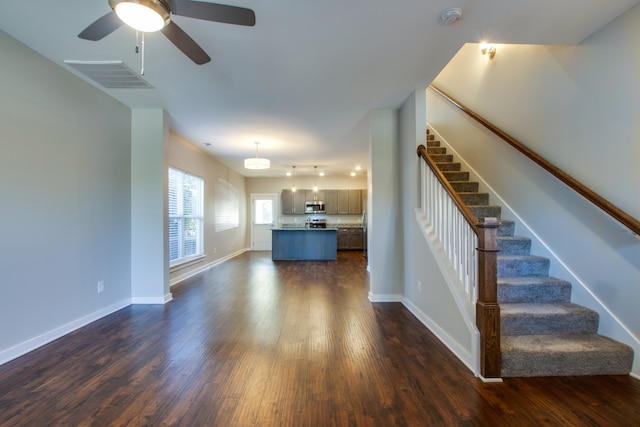 unfurnished living room with dark wood-type flooring and ceiling fan