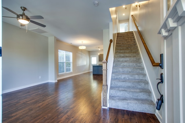 stairs with hardwood / wood-style floors and ceiling fan