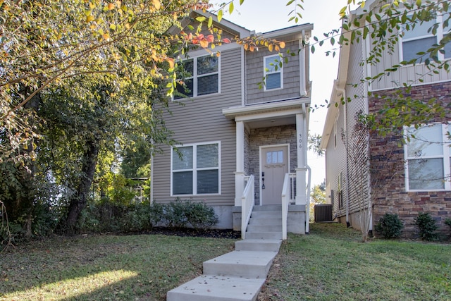 view of front of property featuring a front yard and central AC unit