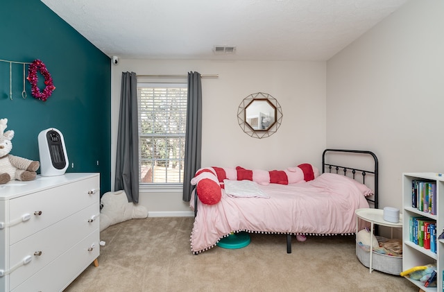 bedroom featuring a textured ceiling and light colored carpet