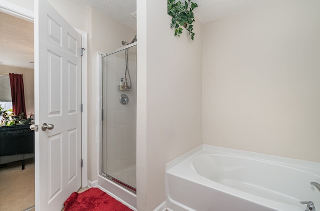 bathroom featuring a textured ceiling and plus walk in shower