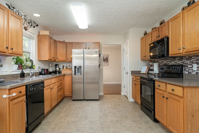 kitchen with sink, black appliances, a textured ceiling, and backsplash