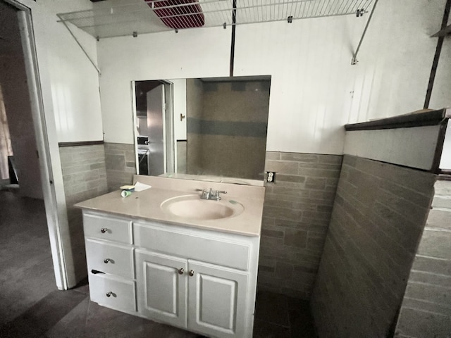 bathroom featuring vanity and tile walls