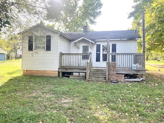 back of property featuring a wooden deck and a lawn