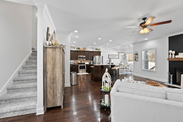 living room with ceiling fan, ornamental molding, and dark hardwood / wood-style floors