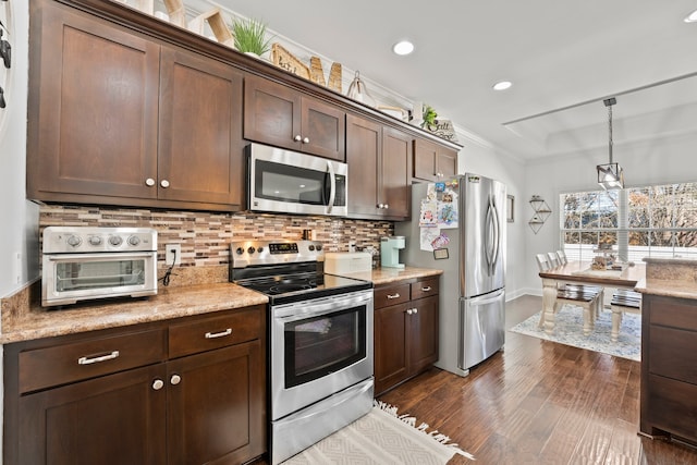 kitchen featuring dark brown cabinets, hanging light fixtures, stainless steel appliances, dark wood-type flooring, and crown molding