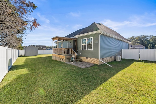 back of property with a deck, a lawn, and ceiling fan