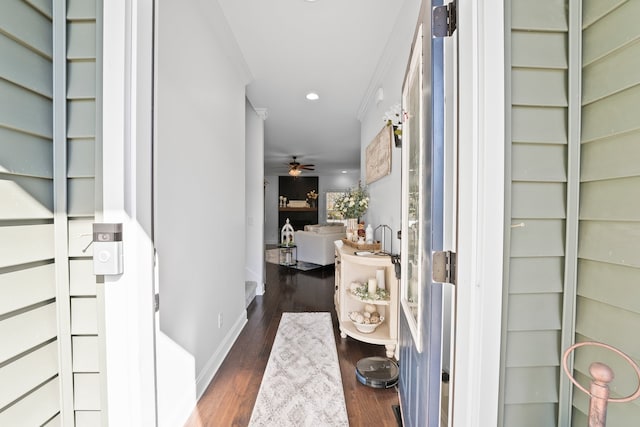 hallway with dark wood-type flooring and ornamental molding