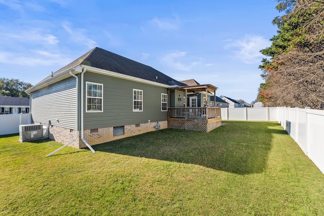 rear view of property featuring central air condition unit, a deck, and a lawn