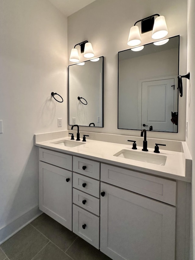 full bathroom featuring double vanity, tile patterned flooring, baseboards, and a sink