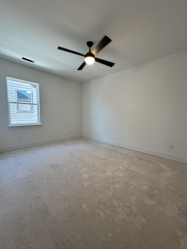 spare room with ceiling fan and baseboards