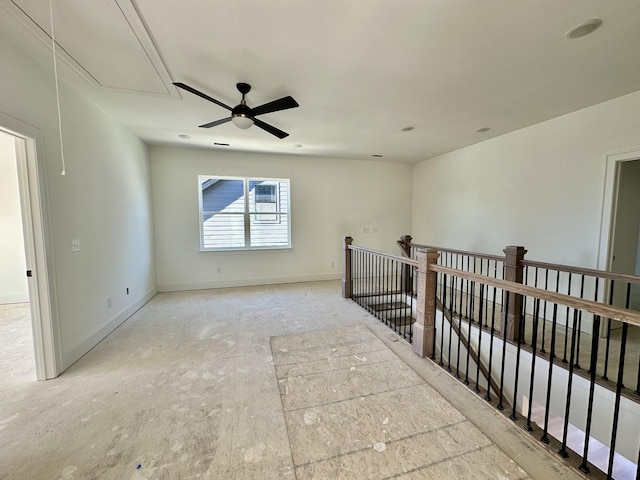 empty room with attic access and baseboards