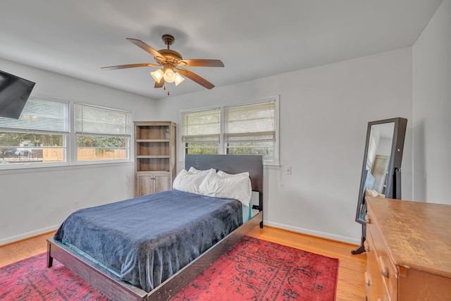 bedroom with hardwood / wood-style flooring, multiple windows, and ceiling fan