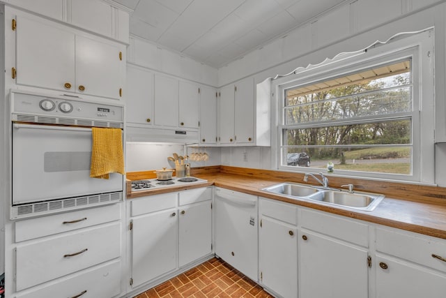 kitchen with white cabinetry, sink, and white appliances