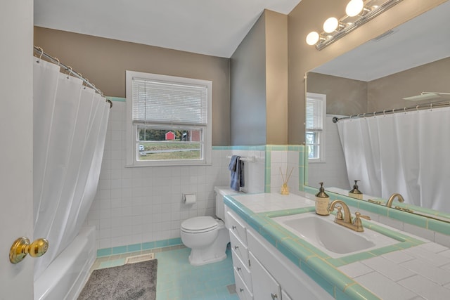 full bathroom with shower / bath combo, toilet, tile walls, vanity, and tile patterned flooring