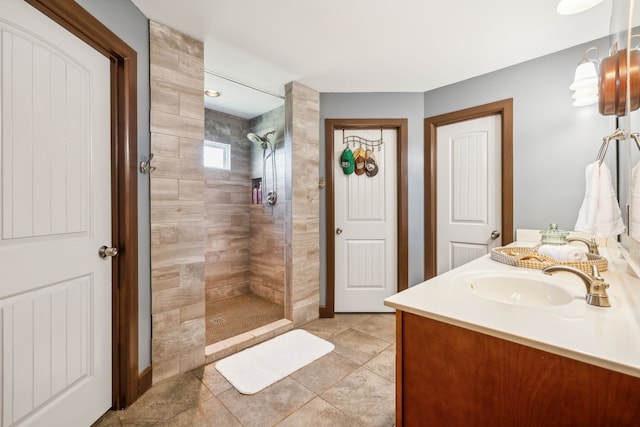 bathroom featuring a tile shower, tile patterned flooring, and vanity