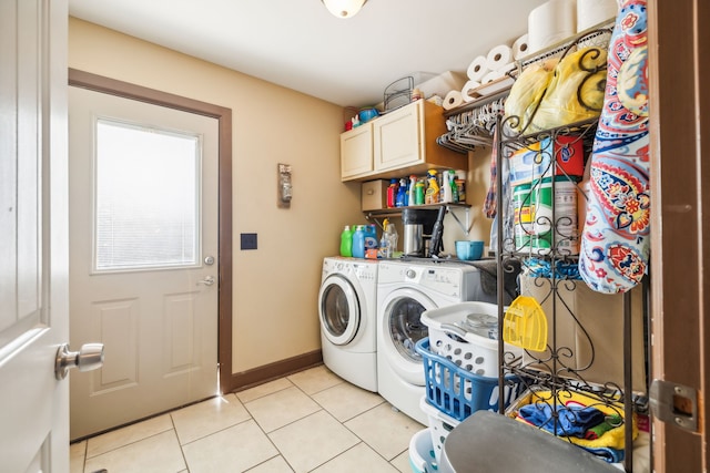 washroom featuring light tile patterned flooring, washer and dryer, and cabinets