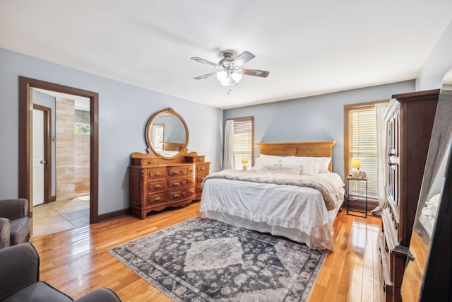 bedroom with ensuite bath, light wood-type flooring, and ceiling fan