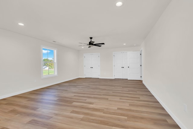 interior space featuring two closets, light hardwood / wood-style floors, and ceiling fan