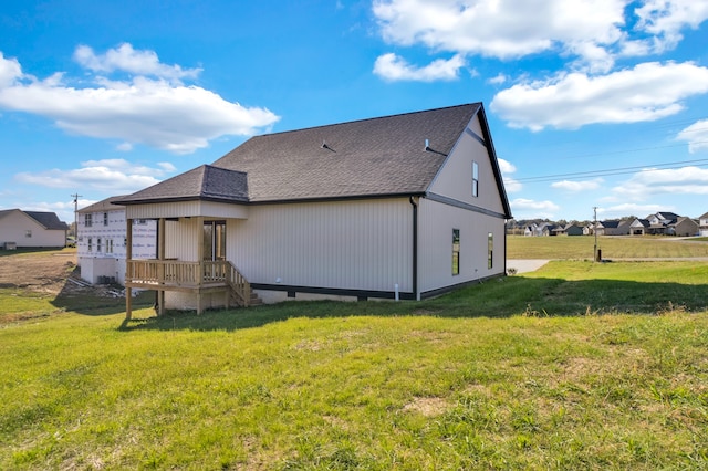 rear view of property featuring a lawn