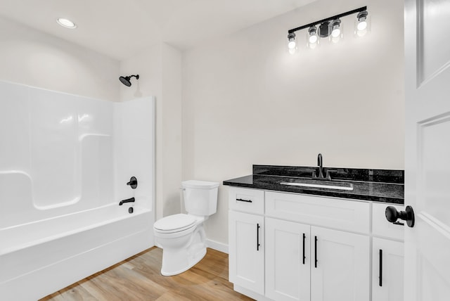 full bathroom with toilet, hardwood / wood-style floors, vanity, and tub / shower combination