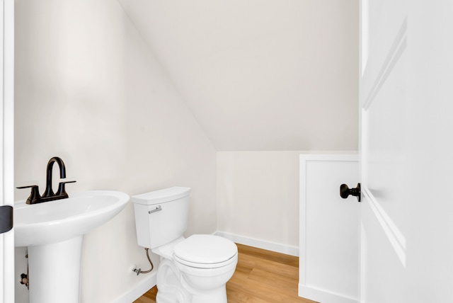 bathroom with toilet, hardwood / wood-style flooring, and lofted ceiling