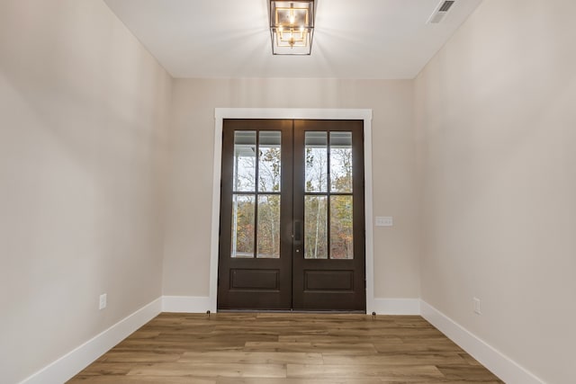 entryway with french doors and light hardwood / wood-style flooring