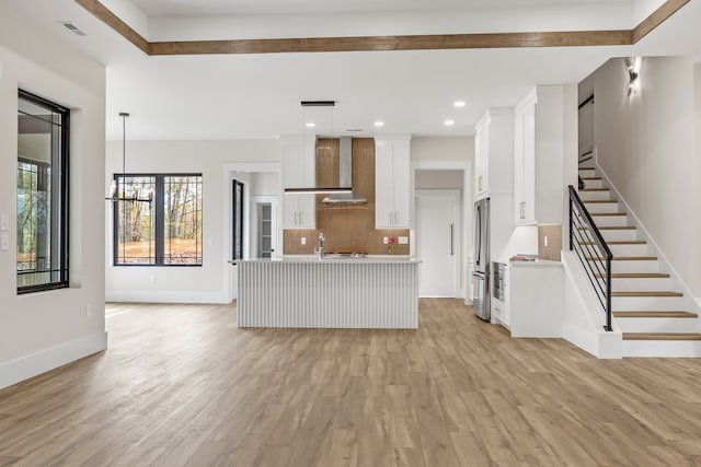 unfurnished living room with a chandelier and light wood-type flooring