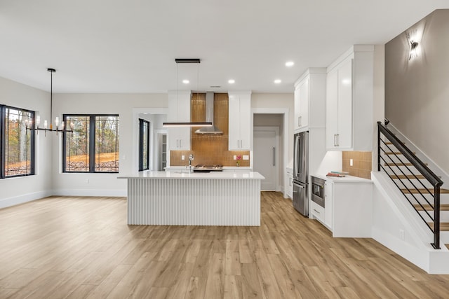 kitchen with pendant lighting, white cabinets, a center island with sink, and appliances with stainless steel finishes