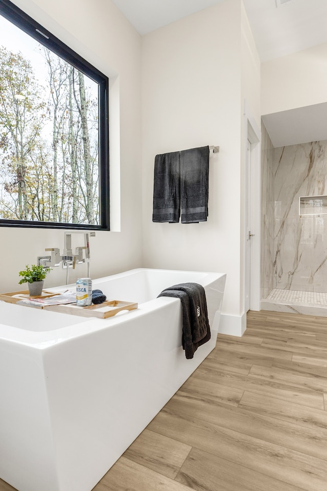 bathroom featuring shower with separate bathtub and hardwood / wood-style flooring