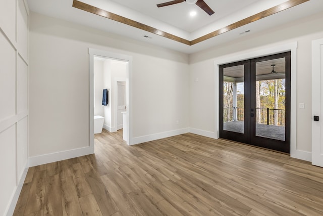 empty room with ceiling fan, light hardwood / wood-style flooring, and french doors