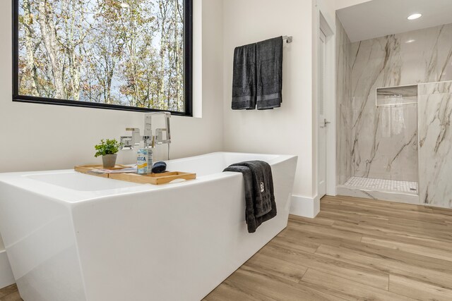 bathroom with separate shower and tub and wood-type flooring