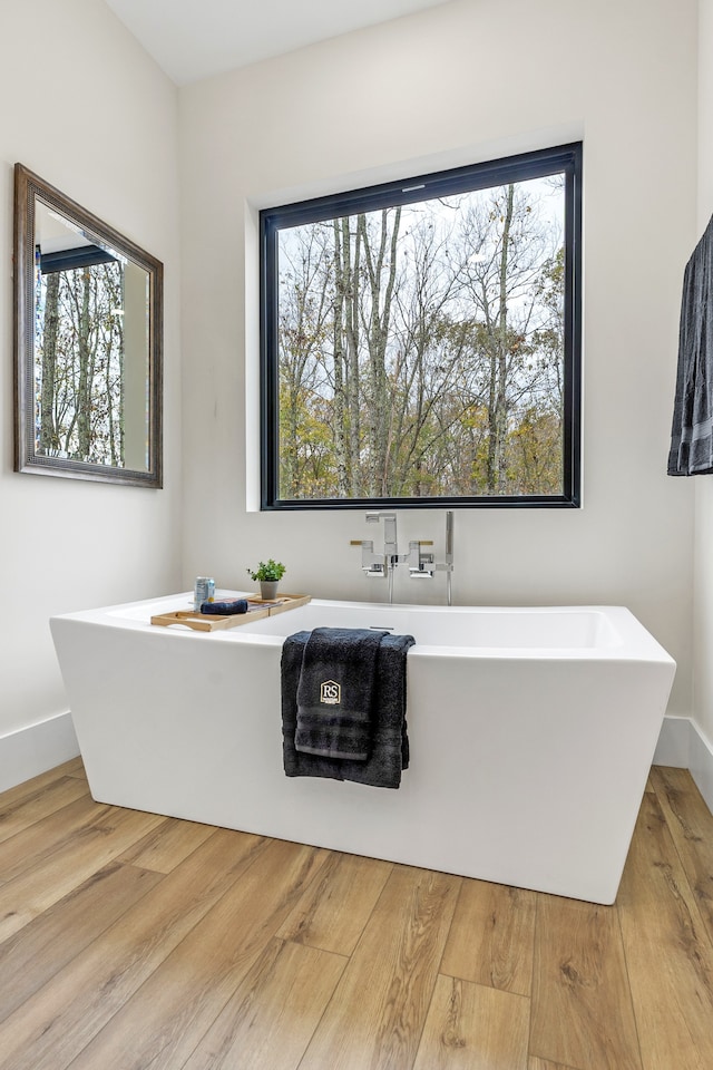 bathroom with hardwood / wood-style floors and a bath