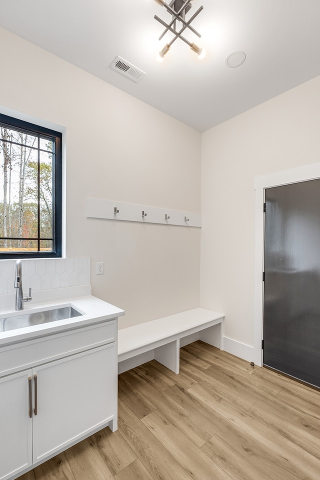 mudroom with sink and light hardwood / wood-style flooring