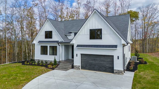 modern farmhouse featuring a garage and a front lawn