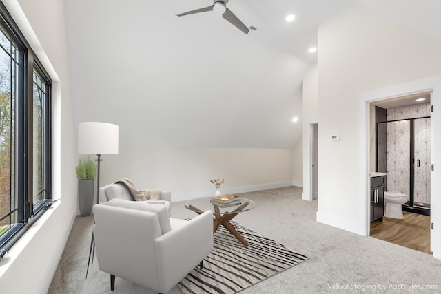 living area featuring light colored carpet, high vaulted ceiling, and ceiling fan