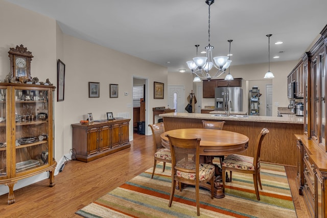 dining area featuring light hardwood / wood-style flooring, a chandelier, and sink