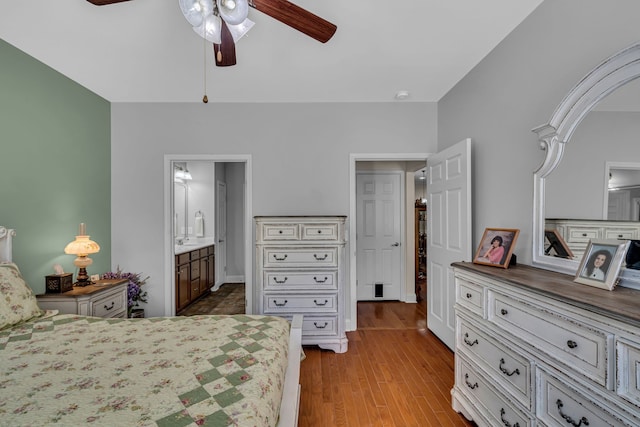 bedroom with light hardwood / wood-style floors, ensuite bathroom, and ceiling fan