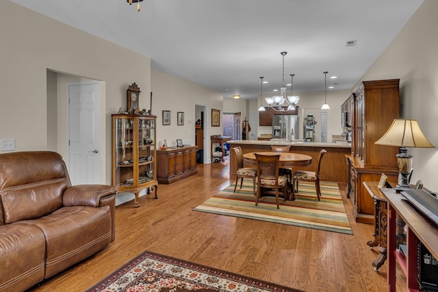 living room with light hardwood / wood-style flooring and a chandelier