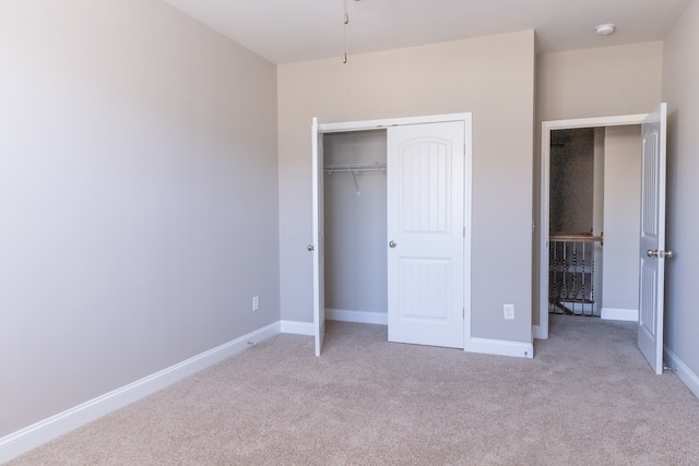 unfurnished bedroom with a closet and light carpet