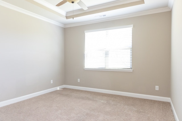 spare room with crown molding, a raised ceiling, carpet, and ceiling fan