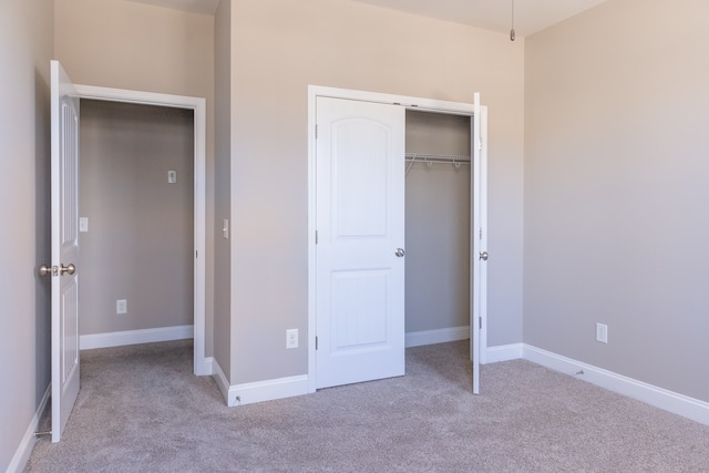 unfurnished bedroom featuring a closet and light carpet