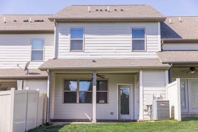 rear view of house with central air condition unit, a lawn, and ceiling fan