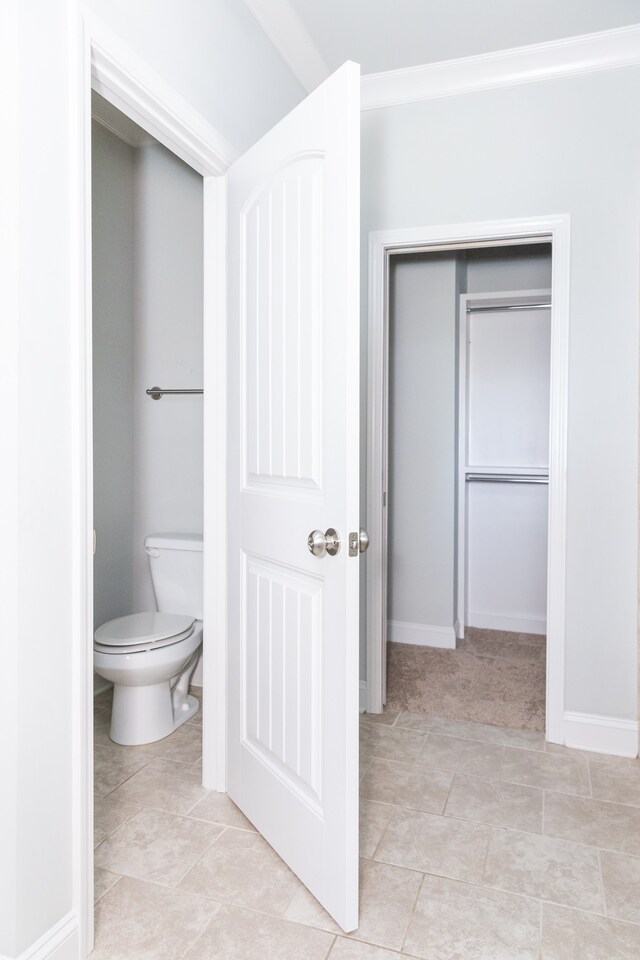 bathroom featuring toilet and tile patterned flooring