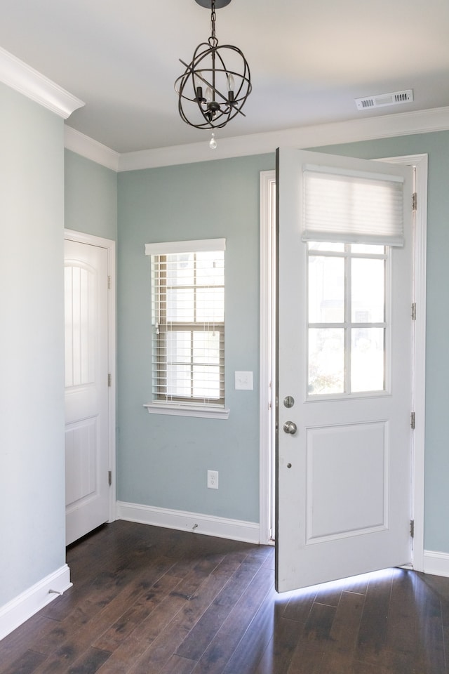 doorway featuring crown molding, a chandelier, and dark hardwood / wood-style flooring