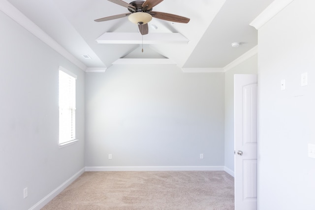 carpeted spare room featuring crown molding, vaulted ceiling, and ceiling fan