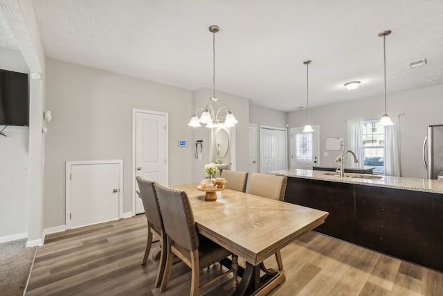 dining space with hardwood / wood-style floors, sink, and a textured ceiling