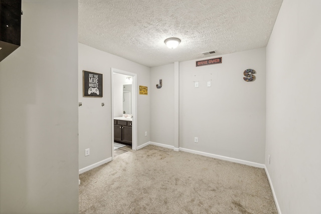 carpeted empty room with a textured ceiling