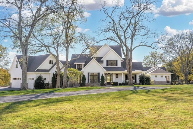 view of front of house with a front lawn, covered porch, and a garage