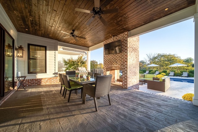 view of patio / terrace with a pool side deck, area for grilling, an outdoor living space with a fireplace, and ceiling fan